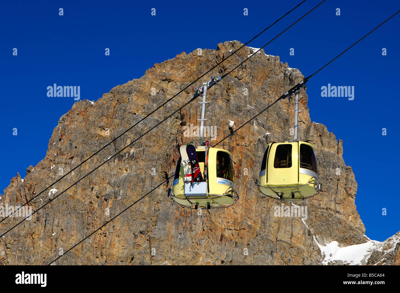 Gondeln einer Seilbahn Ski gegen einen Felsen tragen Gesicht Skigebiet, Trois Vallees, Frankreich Stockfoto