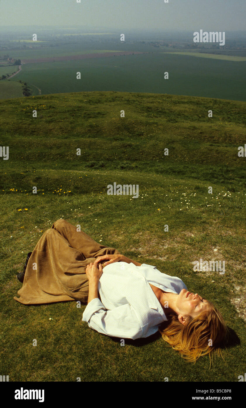 Attraktive 50-etwas Frau liegt auf dem Rasen. Stockfoto