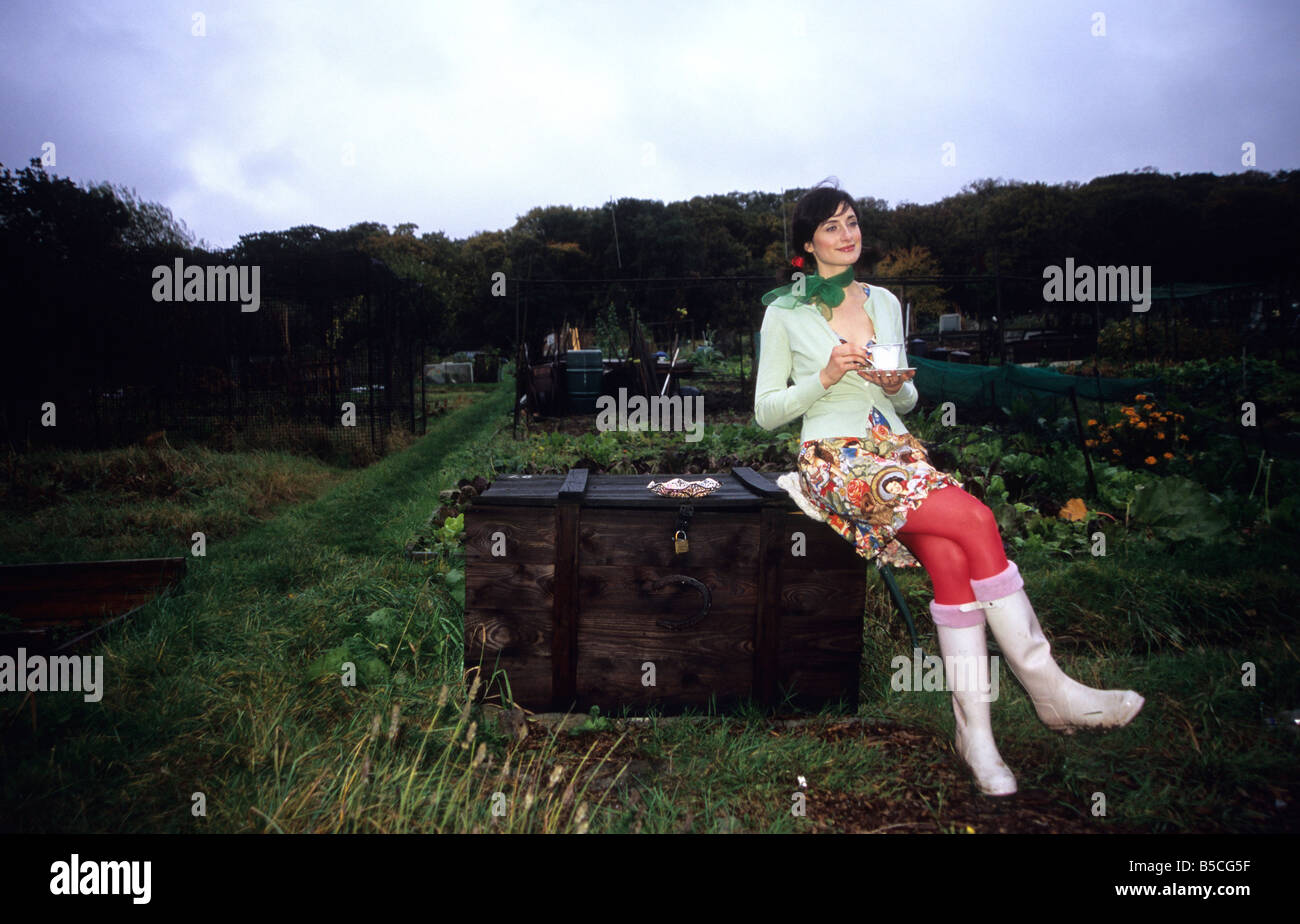 Frau in Kleingärten mit einer Tasse Tee und Gebäck Stockfoto