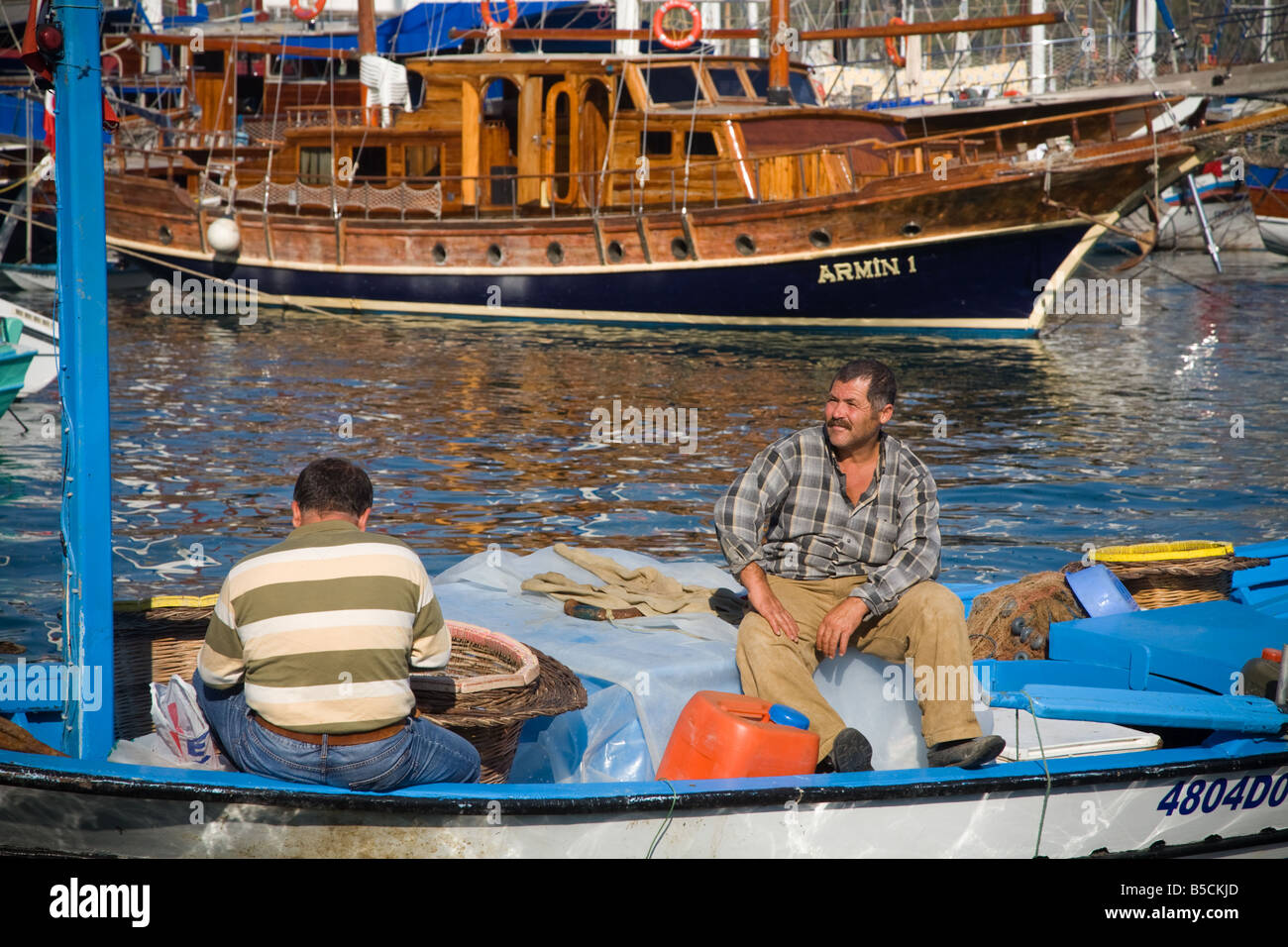Zwei türkische Fischer sitzen in einem kleinen Fischerboot im Mittelmeer bei Fethiye Türkei Stockfoto