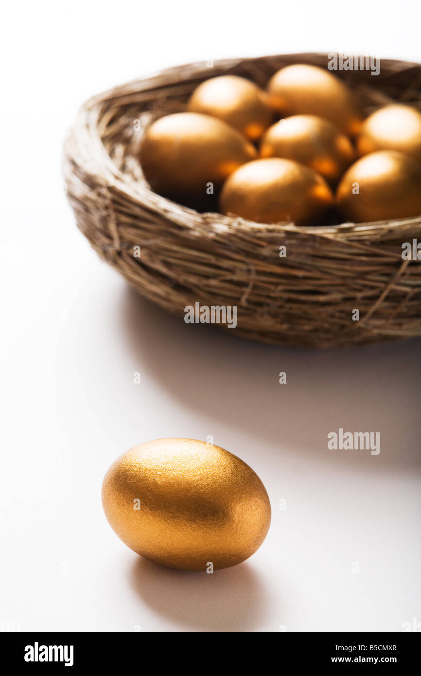 Nest des goldenen Eiern mit einem Ei im Vordergrund Stockfoto