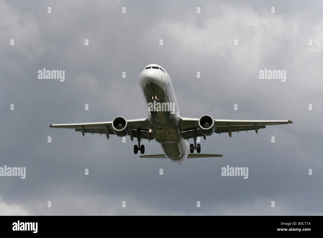 Flugreisen. Airbus A321 Verkehrsflugzeug in einem bewölkten Himmel ankommen. Vorderansicht mit keine Lackierung und proprietäre Informationen gelöscht. Die moderne Luftfahrt. Stockfoto