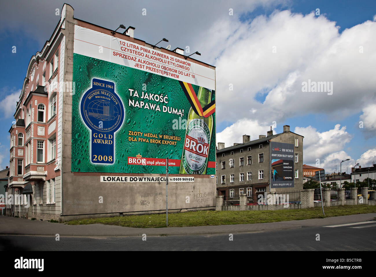 Werbung für polnische Bier am Ende des Reihenhäuser auf Wohnsiedlung Slupsk Polen Stockfoto