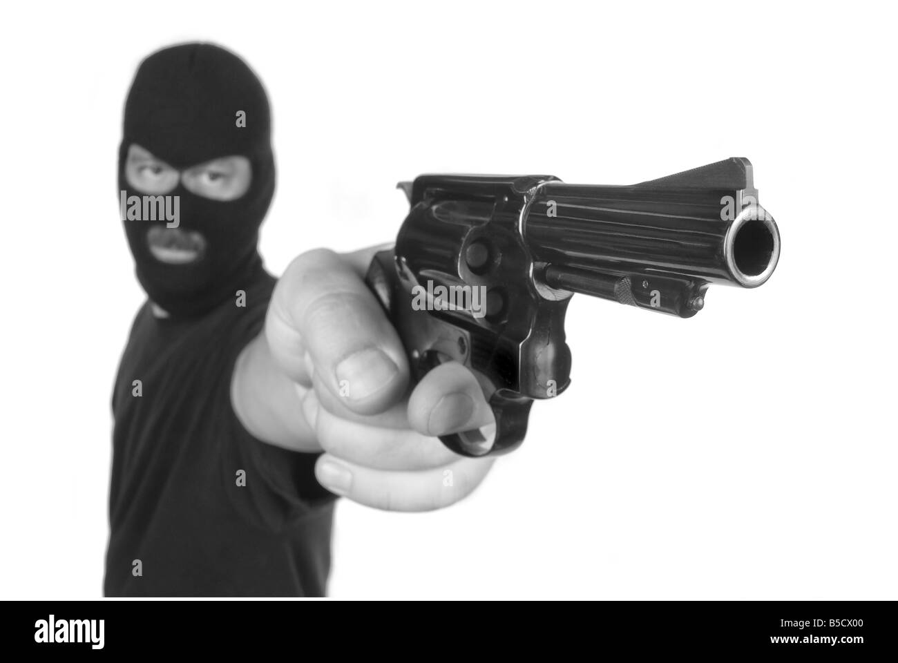Eine Räuber mit versteckten Gesicht zeigt seine Waffe in einem Raub-Versuch Stockfoto