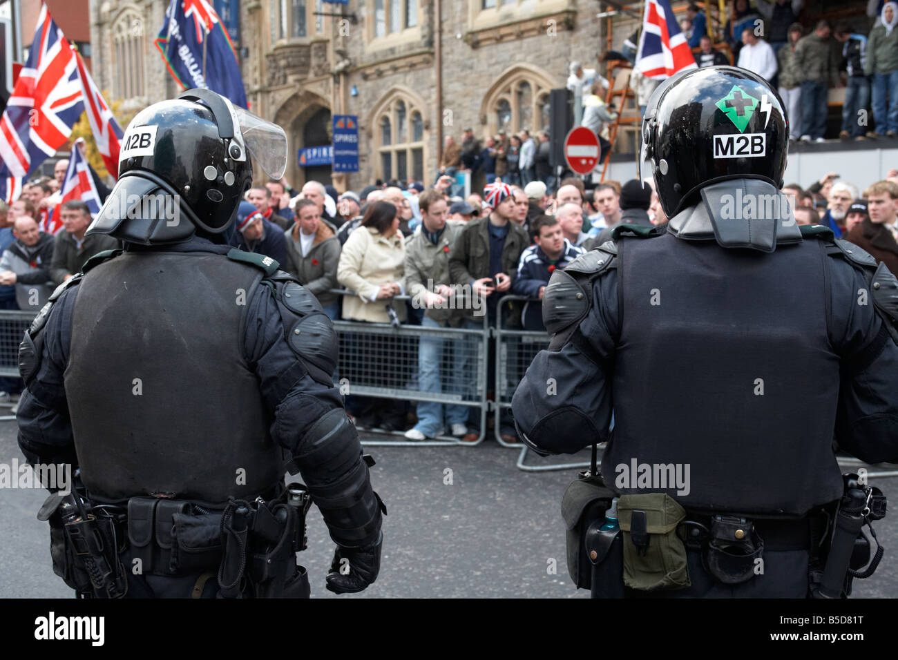 zwei PSNI Police Service of Northern Ireland Riot Kontrollbeamten stehende Bewachung während Loyalist Protest Parade Belfast Stadt Stockfoto