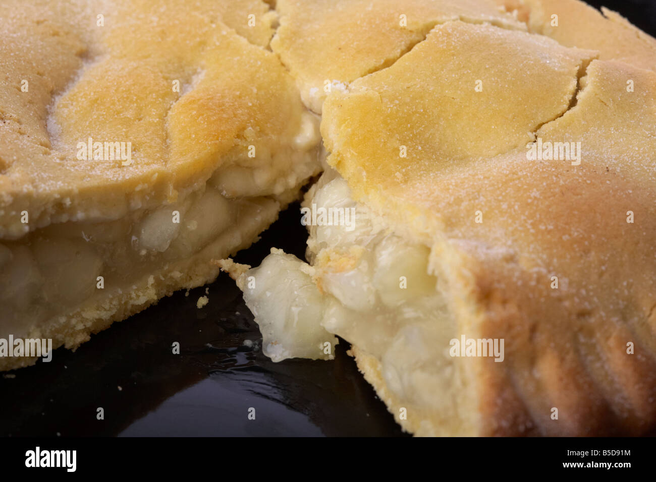 Nahaufnahme eines irischen Bramley Apfelkuchen Kuchen mit Scheibe auf einer schwarzen Platte herausgenommen Stockfoto