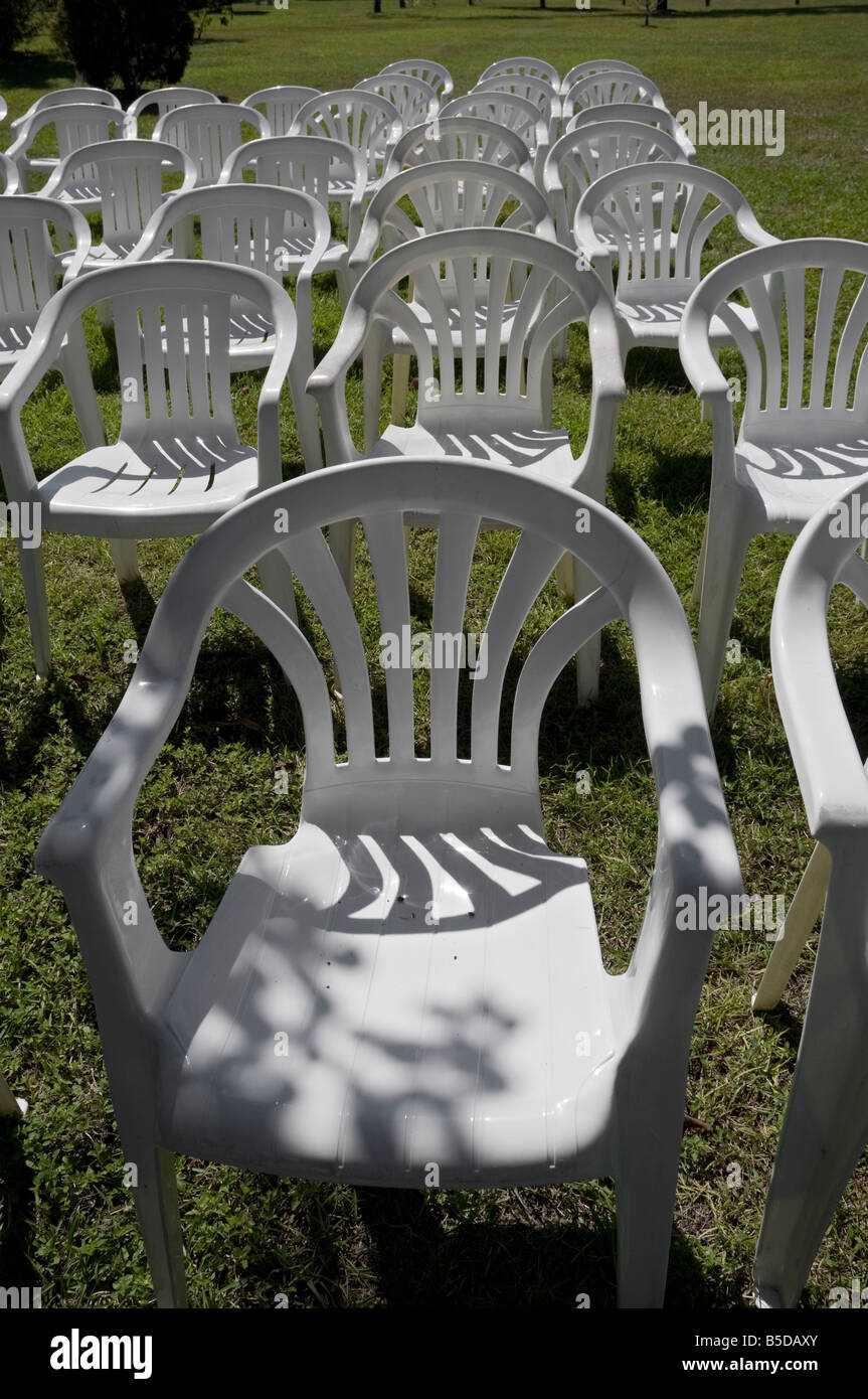 Line-up der weißen Stühlen im Garten Stockfoto