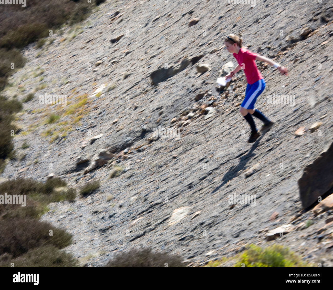Mädchen-Orientierungsläufer steinigen Hang Wales UK Mädchen schnell liefen ist scharf und den Hintergrund unscharf Stockfoto