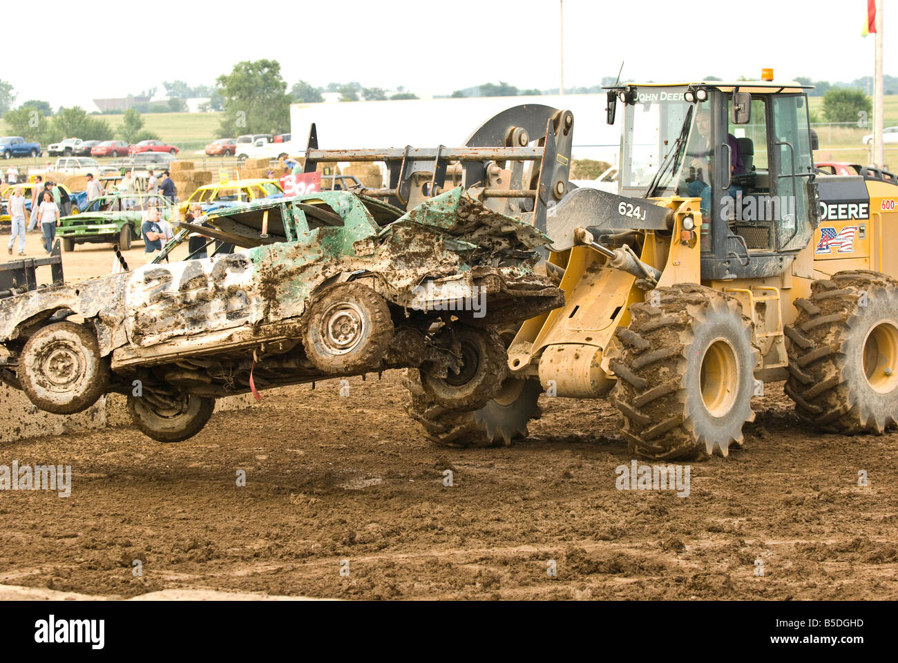Entfernen eines verstümmelten Autos aus der Arena in einem Demolition Derby Traktor Stockfoto