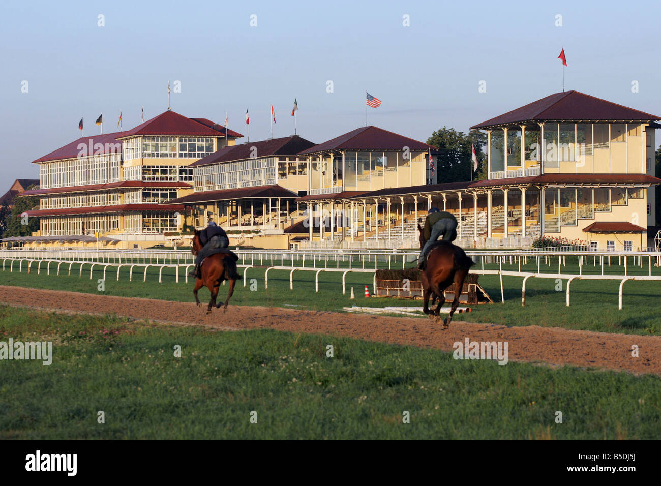 Jockeys und Pferde während des Trainings auf einer Pferderennbahn in den Morgen, Iffezheim, Deutschland Stockfoto
