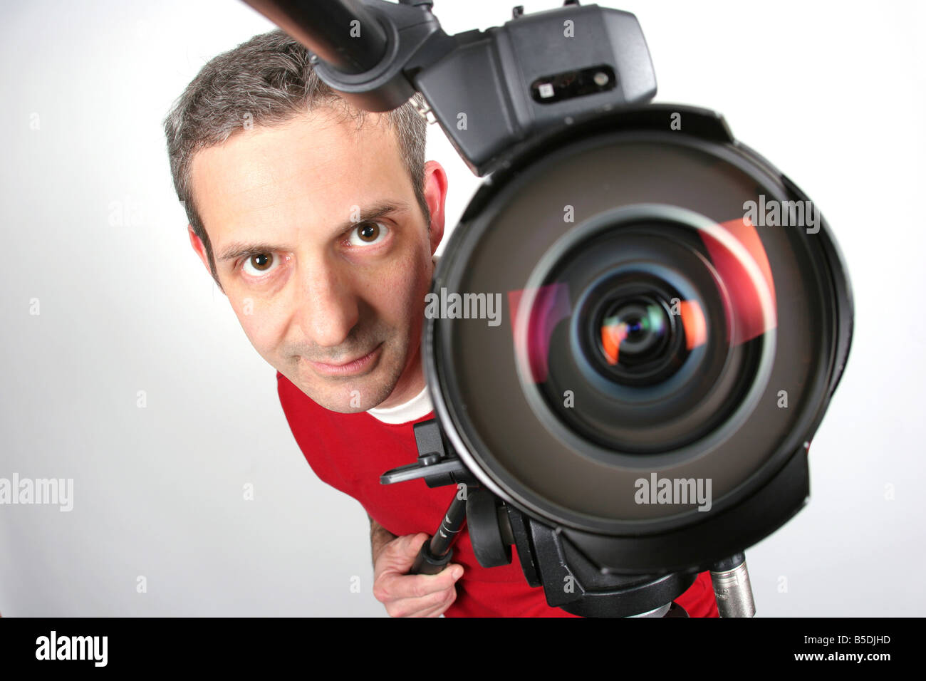 Ein Kamera-Operator spähen aus hinter dem super breit fisheye Objektiv einer kommerziellen Video-Kamera. Stockfoto