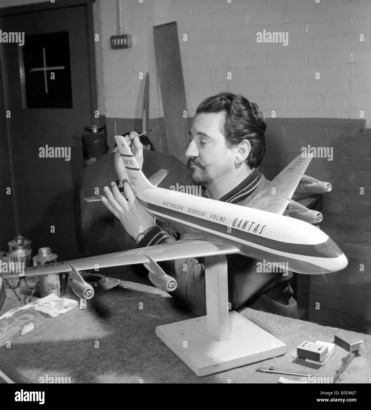 Fabrik wo Flugmodelle für die Reisebüros vorgenommen werden. Männer machen Modellflugzeuge. Modell Hersteller Malerei Höhenleitwerk des Modells ca. 1960 Stockfoto