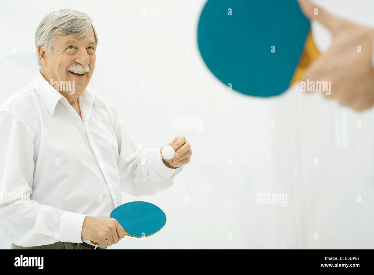 Senior Woman spielen Tischtennis, Hand, die Paddel im Vordergrund Stockfoto