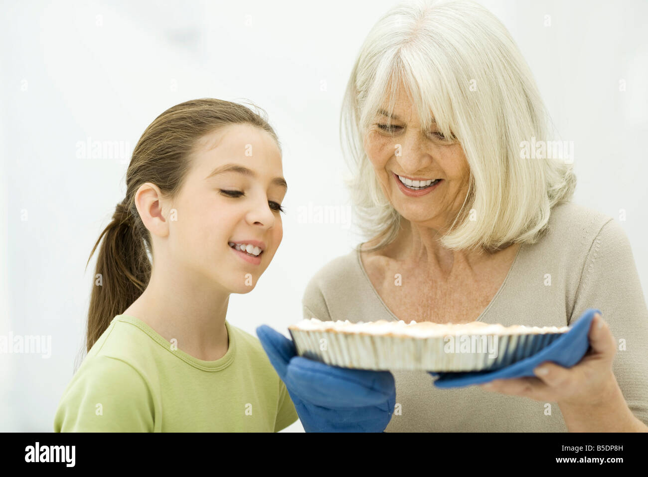 Großmutter und Enkelin blickte auf frisch gebackenem Kuchen Stockfoto