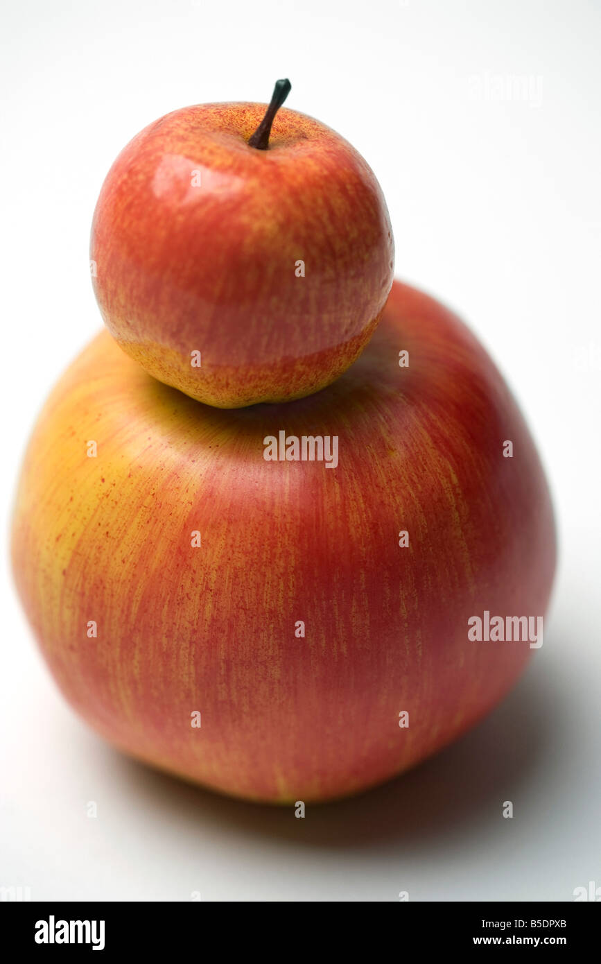Kleiner roter Apfel auf größere Apfel Stockfoto