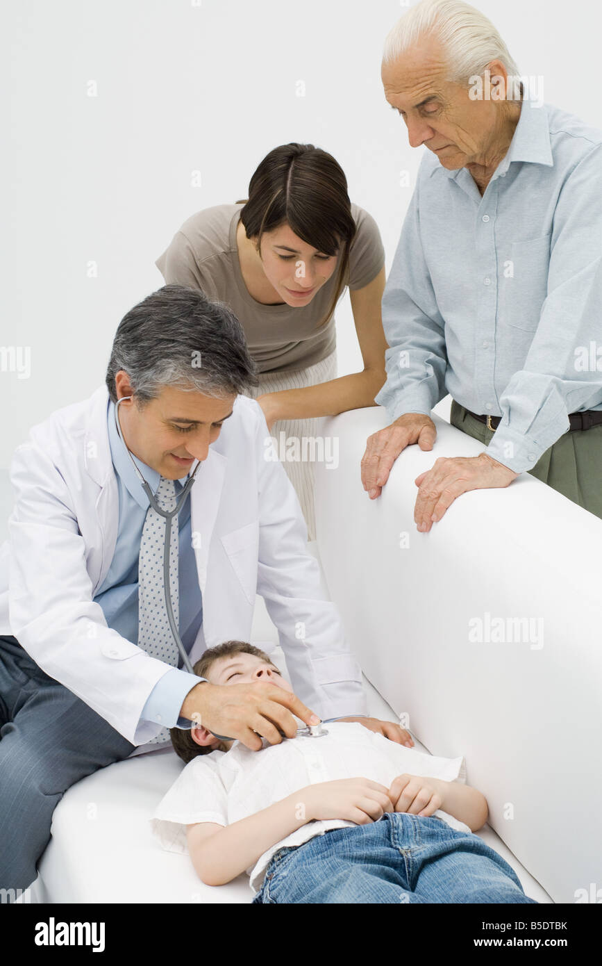 Arzt auf junge Patienten Herz hören Familie beobachten Stockfoto