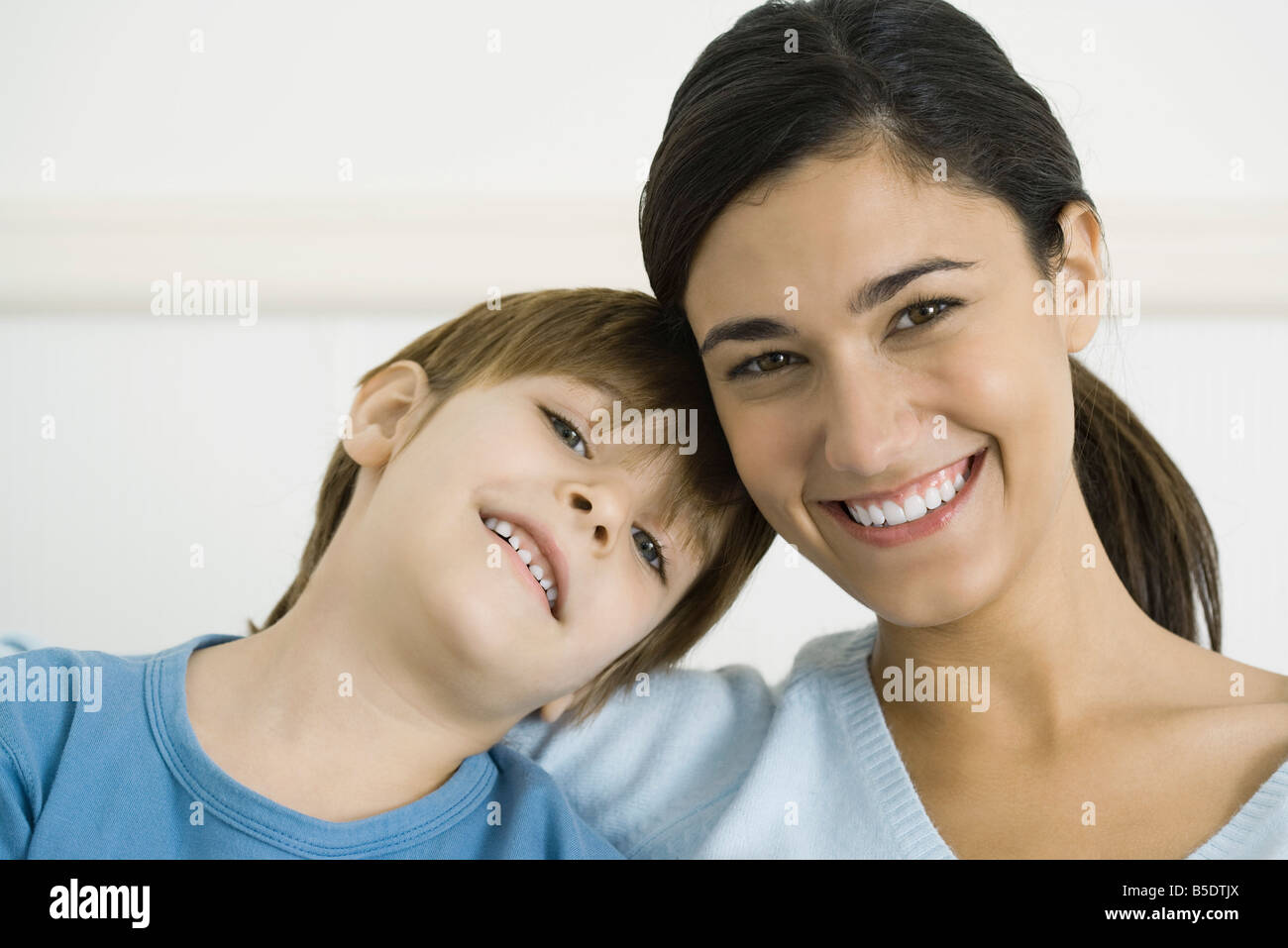 Kleiner Junge lehnte seinen Kopf auf die Schulter seiner Mutter, beide Lächeln, Porträt Stockfoto