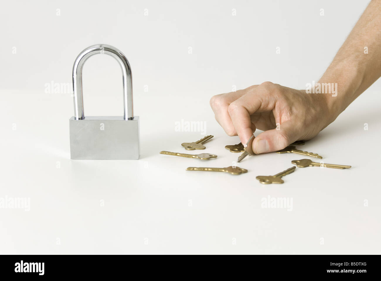 Hand, die Auswahl der Schlüssel zum großen Vorhängeschloss Stockfoto