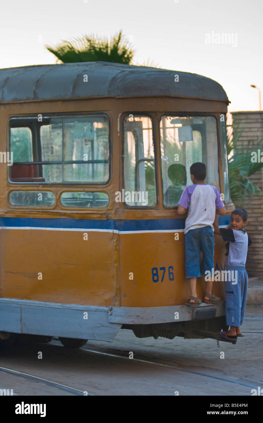 Jungs fangen eine freie Fahrt mit der Straßenbahn in Alexandria Ägypten Stockfoto
