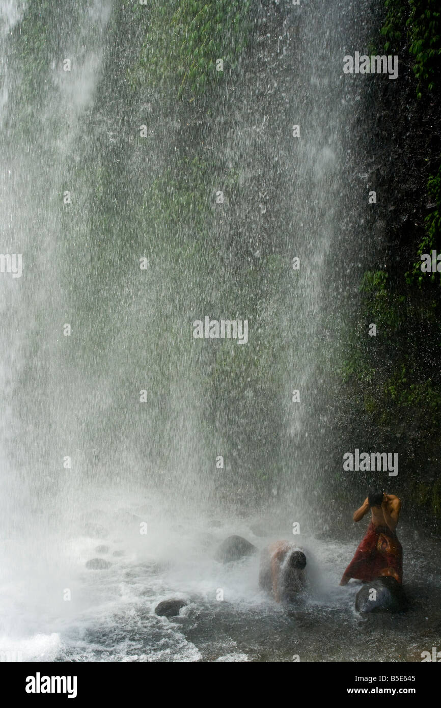 Lokale Mann unter Sindang Gila Wasserfall in Senaru auf der Insel Lombok in Indonesien Stockfoto