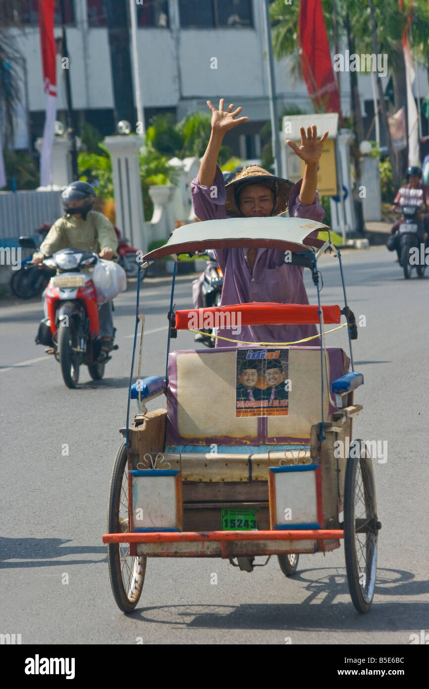 Reiten in einem Becak oder Velo-Rikscha in Makassar auf Sulawesi in Indonesien Stockfoto