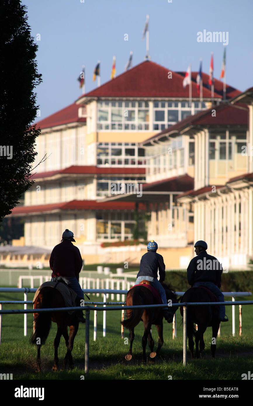 Jockeys und Pferde während des Trainings auf einer Pferderennbahn in den Morgen, Iffezheim, Deutschland Stockfoto