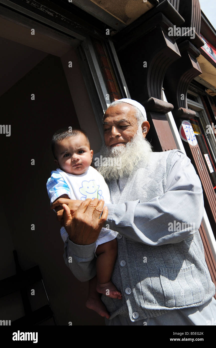 Ein Opa steht mit seinem Enkel vor seinem Haus in Bolton Stockfoto