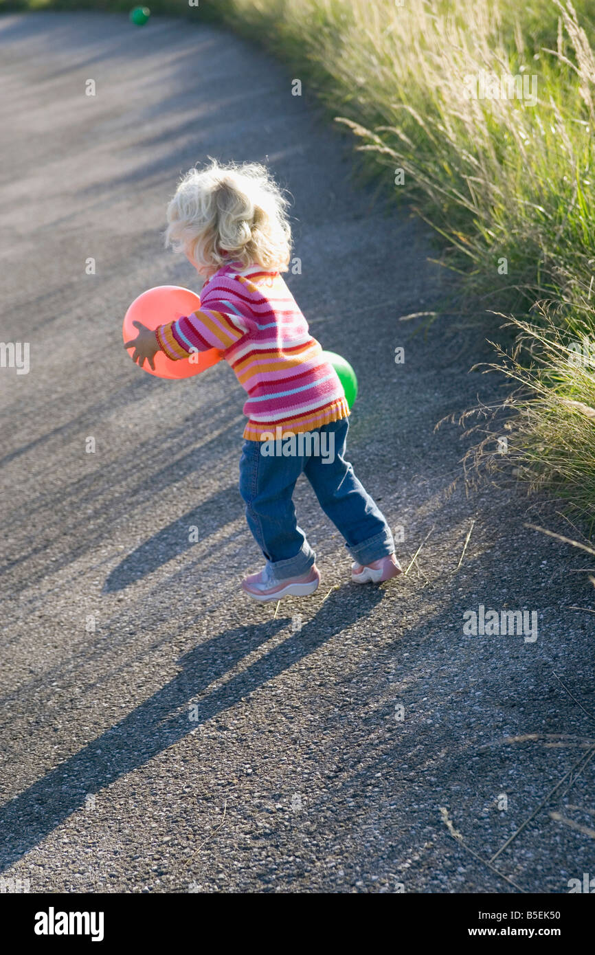 Kleines Mädchen (2-3) Spiel mit Luftballons im Freien, Rückansicht Stockfoto