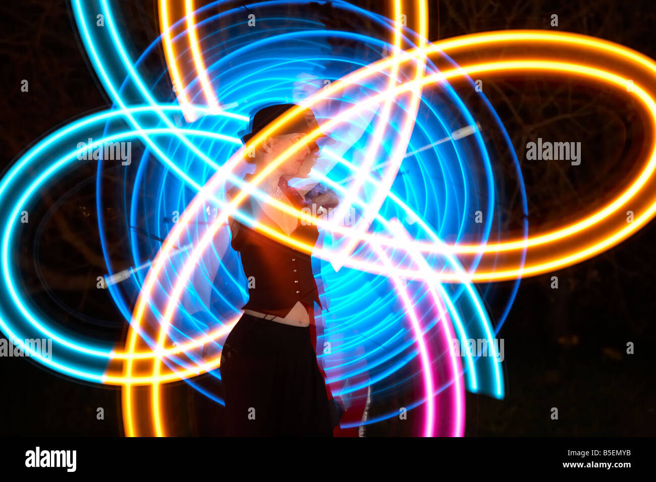 männliche und weibliche Performance-Künstler jonglieren LED Stablicht er mit Licht Stockfoto