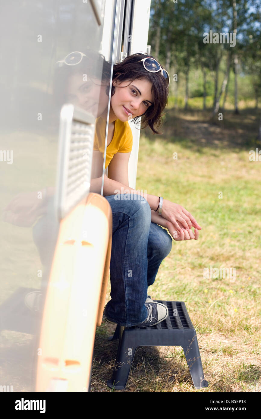 Deutschland, Leipzig, Ammelshainer See, junge Frau sitzt in der Tür des Wohnwagen Stockfoto
