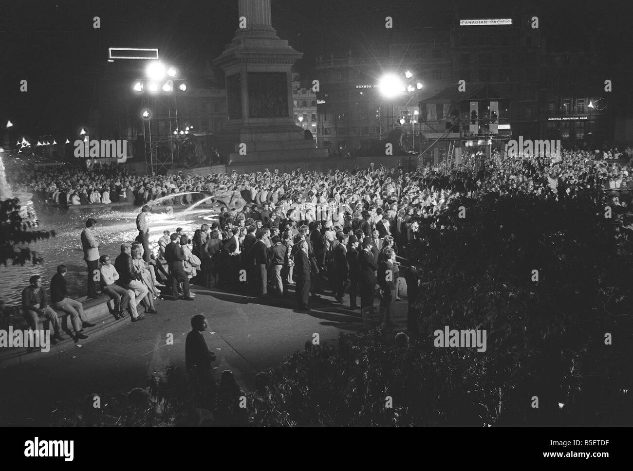 Trafalgar Square in London Juli 1969 versammeln sich spät in der Nacht auf dem Trafalgar Square Zeuge die erste Mondlandung auf Großbildschirm tv errichtet für die Veranstaltung Menschen stehen rund um die Brunnen und Becken Stockfoto