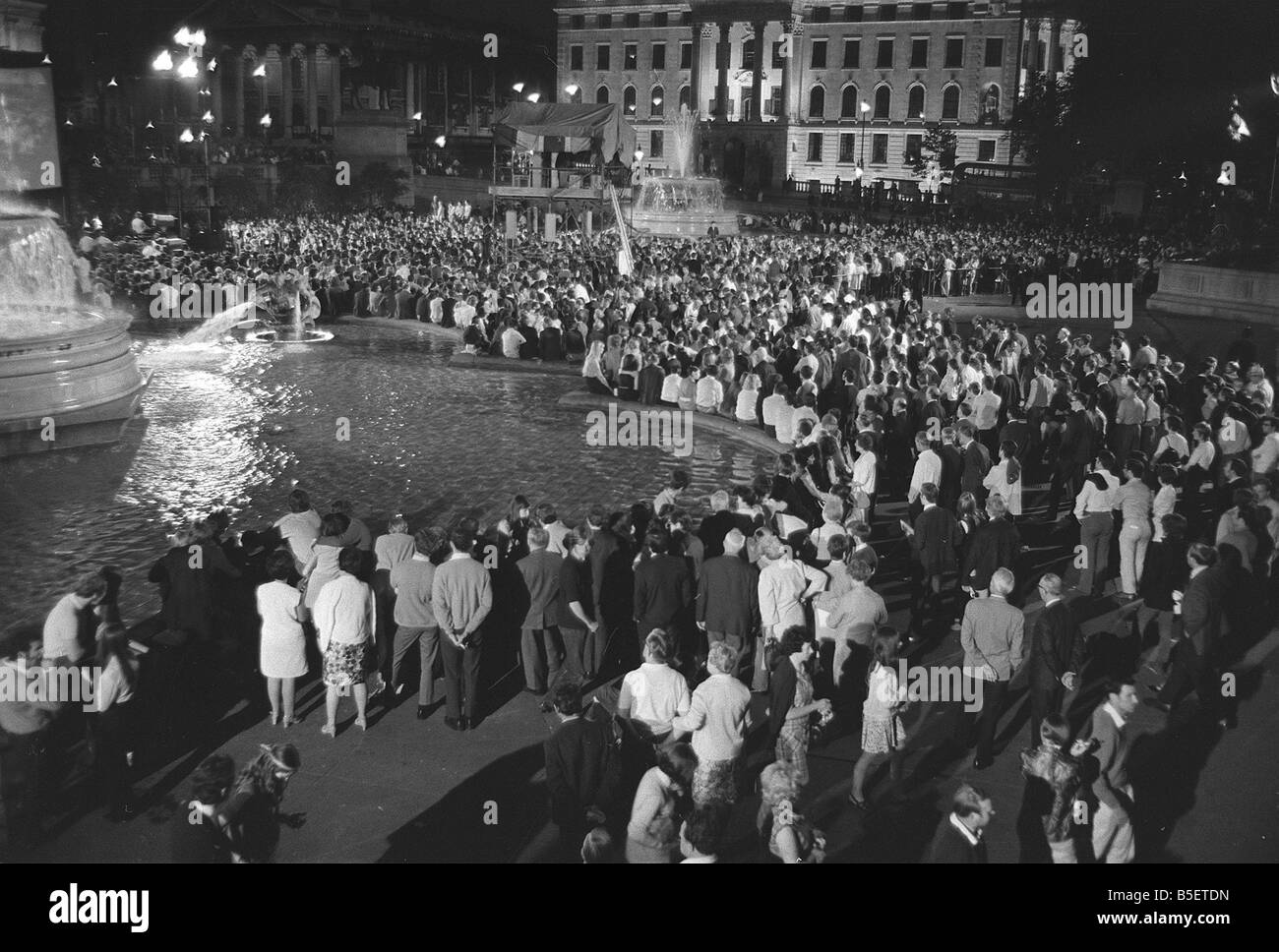 Trafalgar Square in London Juli 1969 versammeln sich spät in der Nacht auf dem Trafalgar Square Zeuge die erste Mondlandung auf Großbildschirm tv errichtet für die Veranstaltung Menschen stehen rund um die Brunnen und Becken Mirrorpix Stockfoto