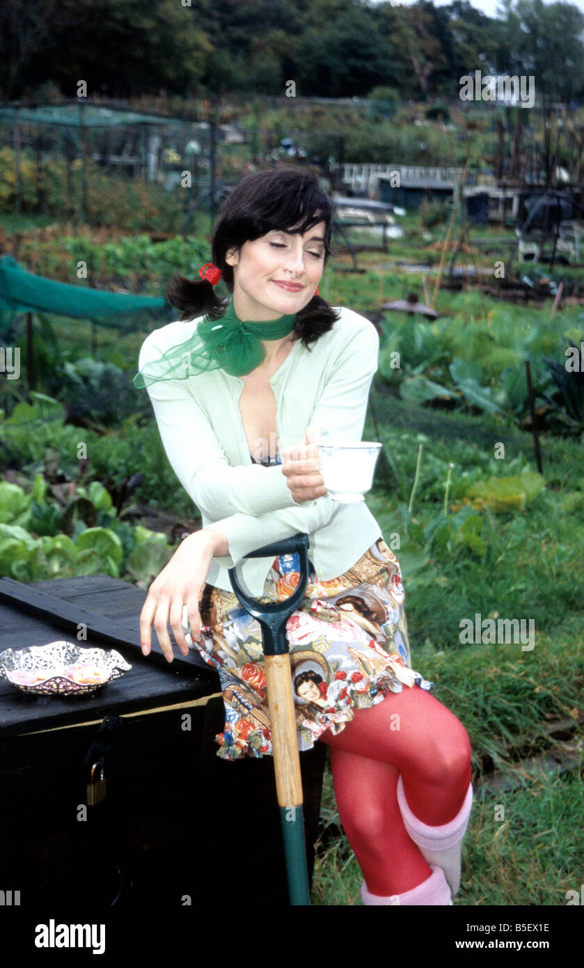 Eine junge Frau mit Tee und Keksen in Zuteilung Stockfoto