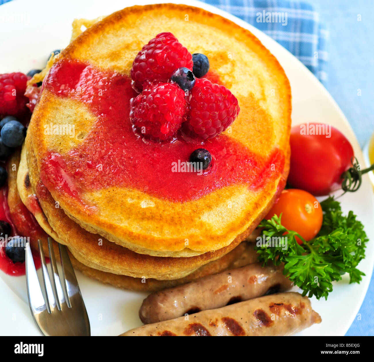 Frühstück mit Buttermilch Pfannkuchen mit Würstchen und frischen Beeren Stockfoto