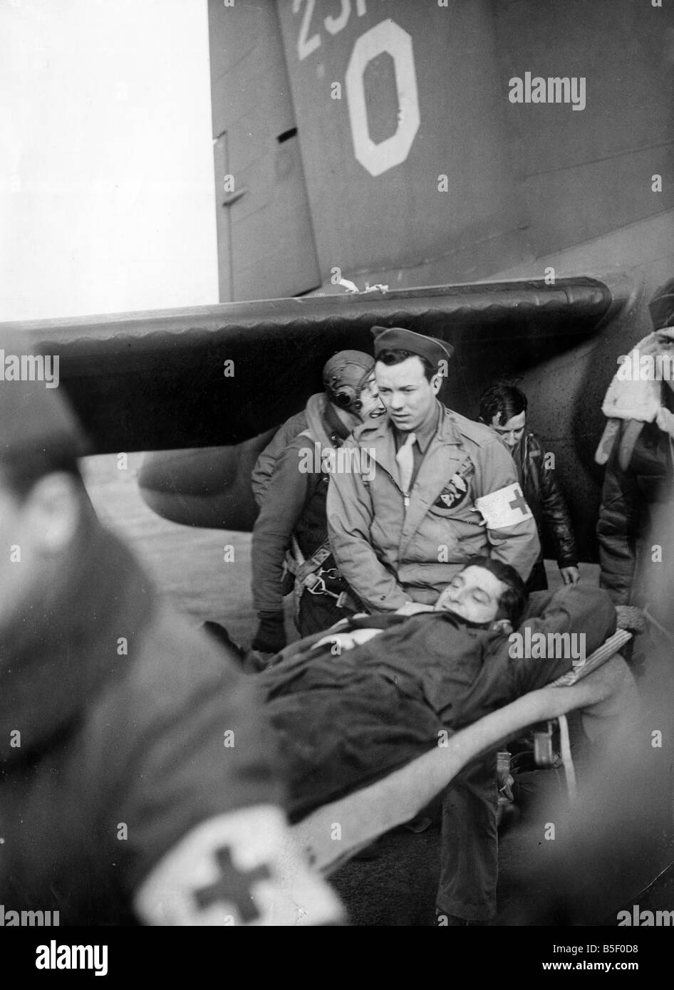 Ein verletzter Luft-Crew-Mitglied der US Eighth Army Air Force ist nach einer Bombardierung Kampagne im besetzten Frankreich im zweiten Weltkrieg März 1944 Sanitätern der B17 Flying Fortess Flugzeug bei einer Basis in England Stockfoto