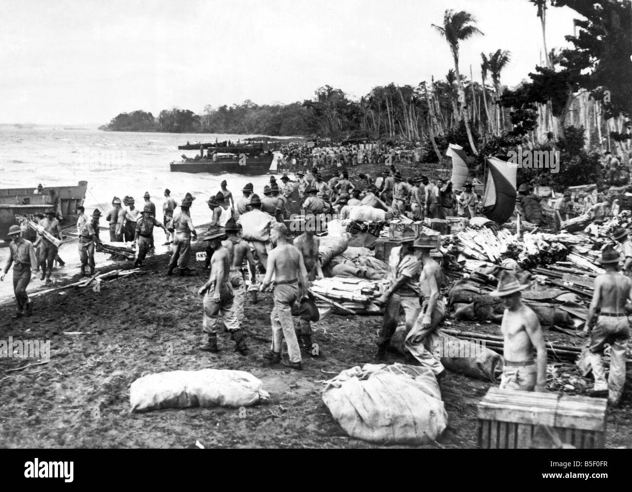 Krieg im Pazifik. Alliierte Soldaten entladen Versorgungsgüter und Ausrüstungsgegenstände an den Strand einer Insel im Pazifik gefangen.; 6. März 1943 Stockfoto