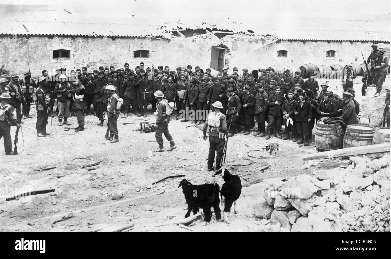 Libyen. Britische Infanterie im Besitz einer italienischen Festung nach der Einnahme von Derna, mit ihren Gefangenen aufgereiht auf dem Platz.; 1. März 1941. Stockfoto