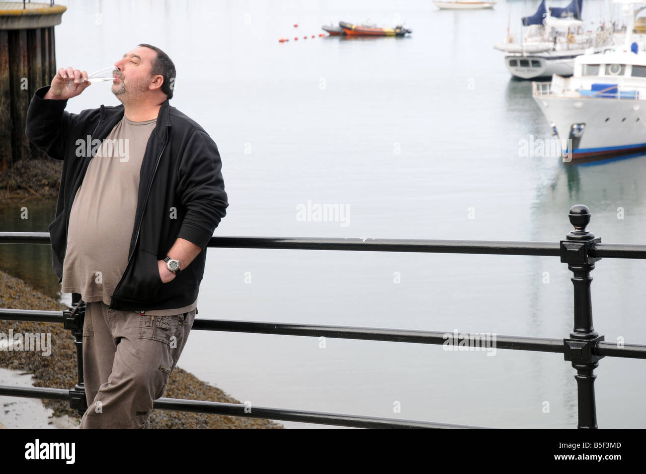 Ein unordentlicher Mensch trinkt Champagner in Falmouth Oyster Festival, UK Stockfoto
