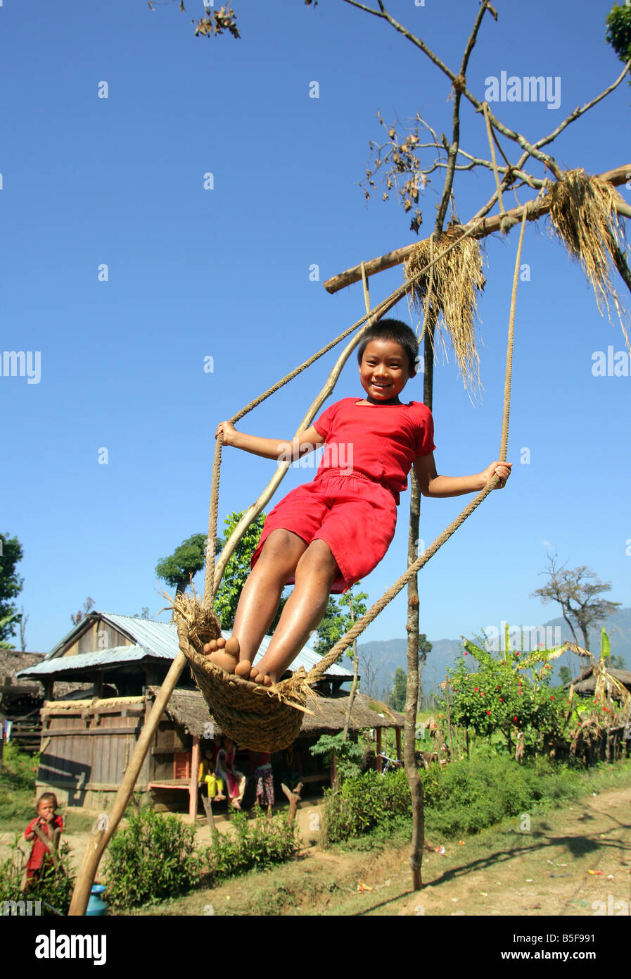 -Mädchen auf einer Schaukel in einem Dorf in Nepal Stockfoto