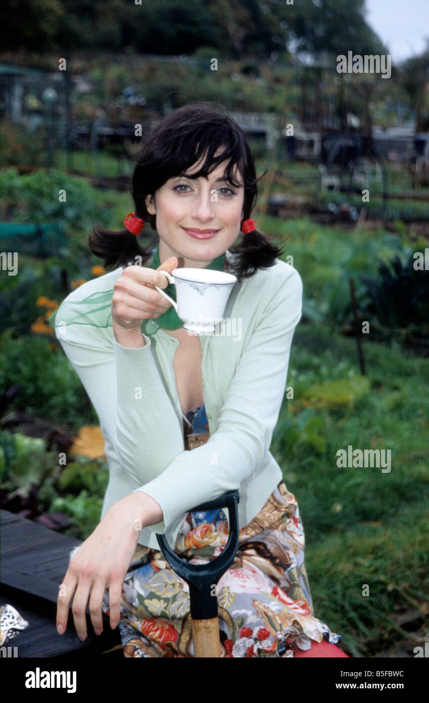 Eine junge Frau mit Tee und Keksen in Zuteilung Stockfoto
