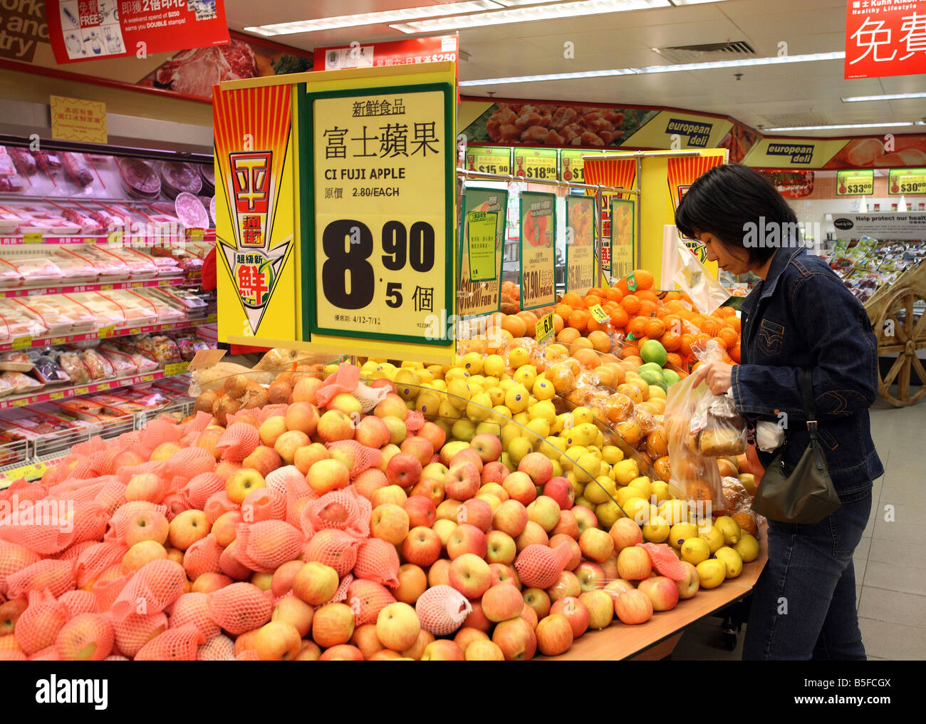 Frau kauft Früchte in einem Supermarkt in Hong Kong, China Stockfoto