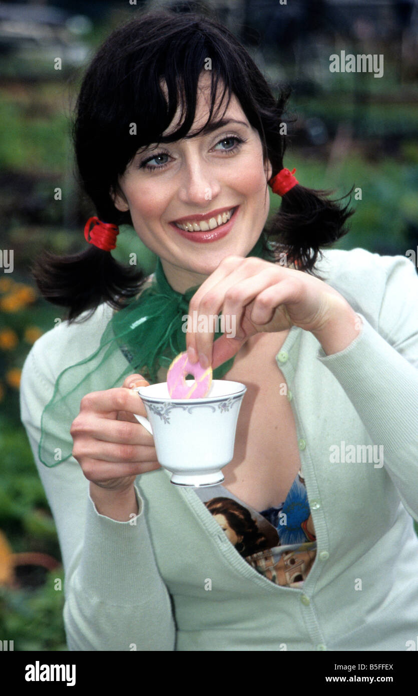 Eine junge Frau mit Tee und Keksen in Zuteilung Stockfoto