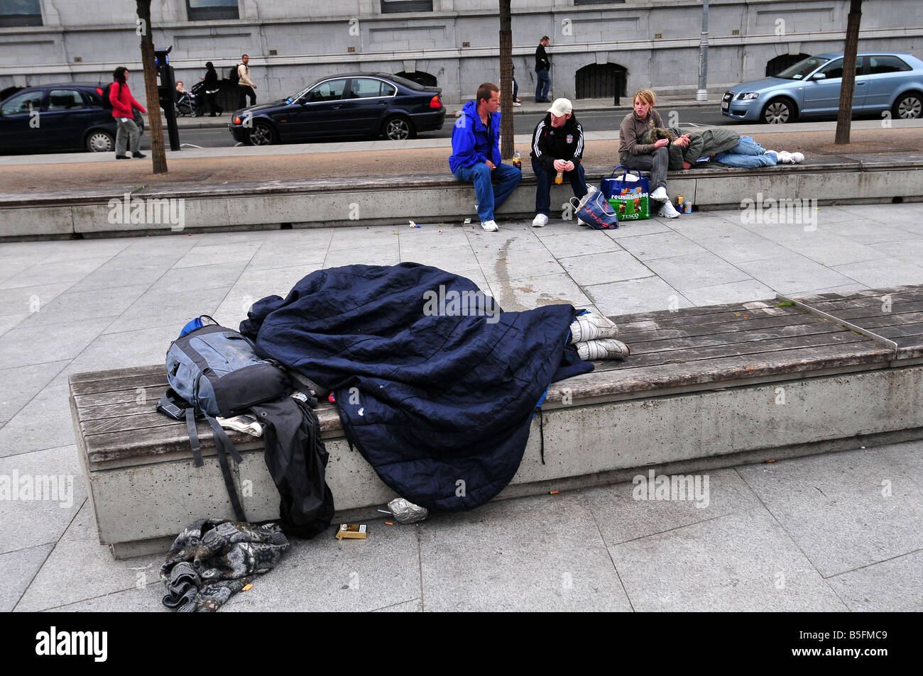 ein Obdachloser schläft auf einer Bank in Dublin Irland Stockfoto