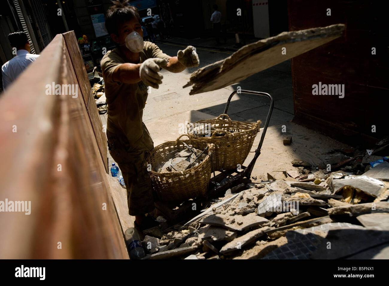 Ein Arbeiter zieht Bauschutt in Hong Kong, China. Stockfoto