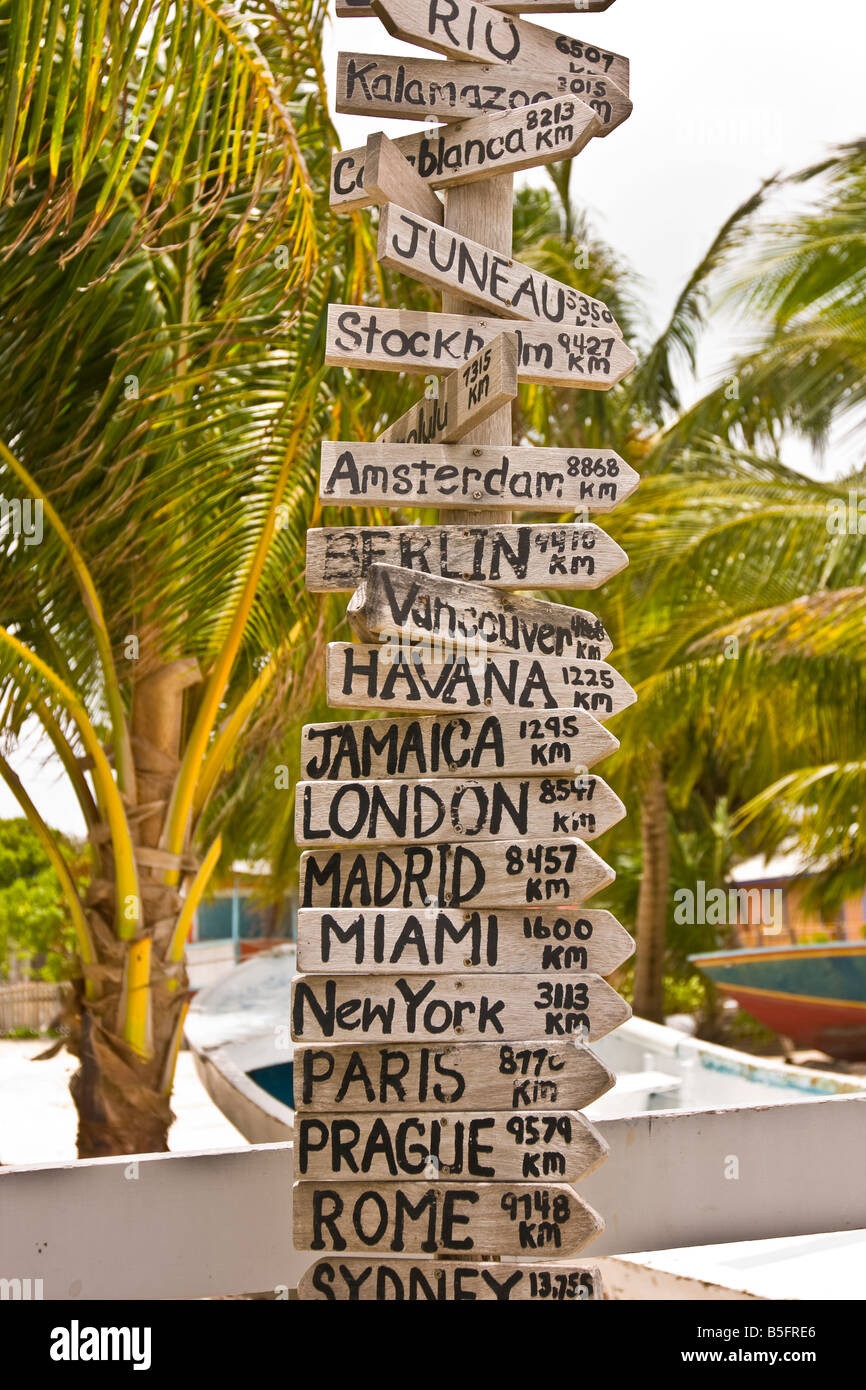 CAYE CAULKER BELIZE Sign Post mit vielen Zeichen, die Entfernung in Kilometern zu Großstädten auf der ganzen Welt auflisten Stockfoto