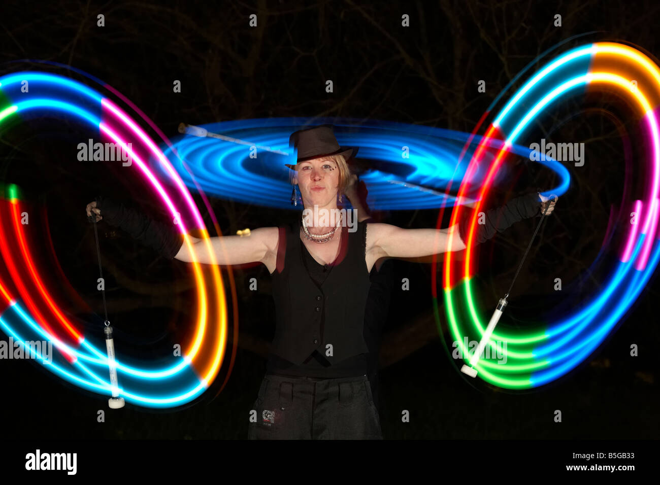 männliche und weibliche Performance-Künstler jonglieren LED Stablicht er mit Licht Stockfoto