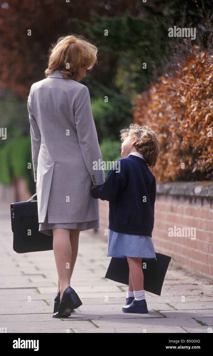 Rückansicht des eine berufstätige Mutter zu Fuß ihre Tochter zur Schule zum Jahresbeginn einen neuen Begriff Stockfoto