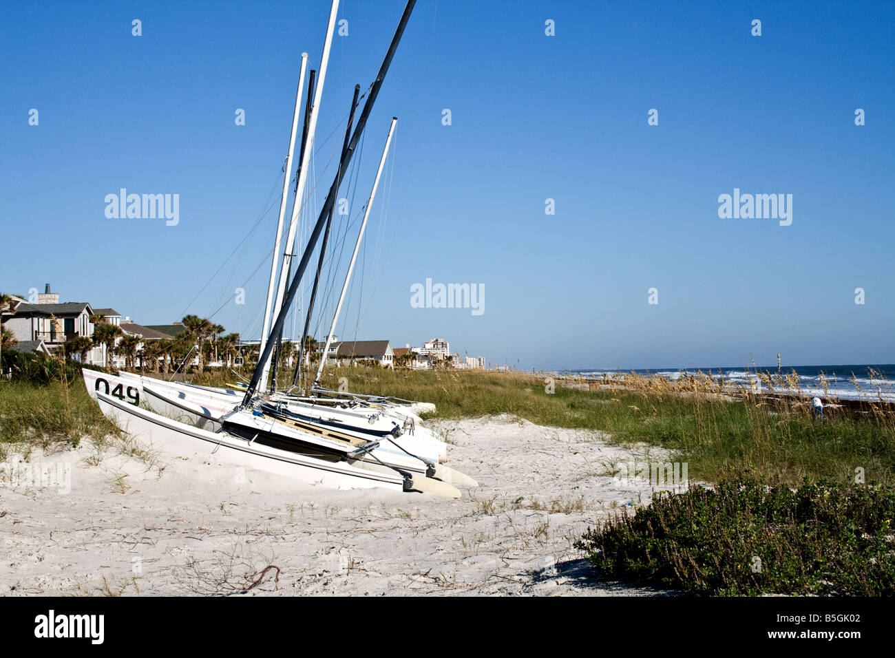 Segelboot mit Segel unten am Strand mit Algen in Jacksonville Beach, Florida Stockfoto