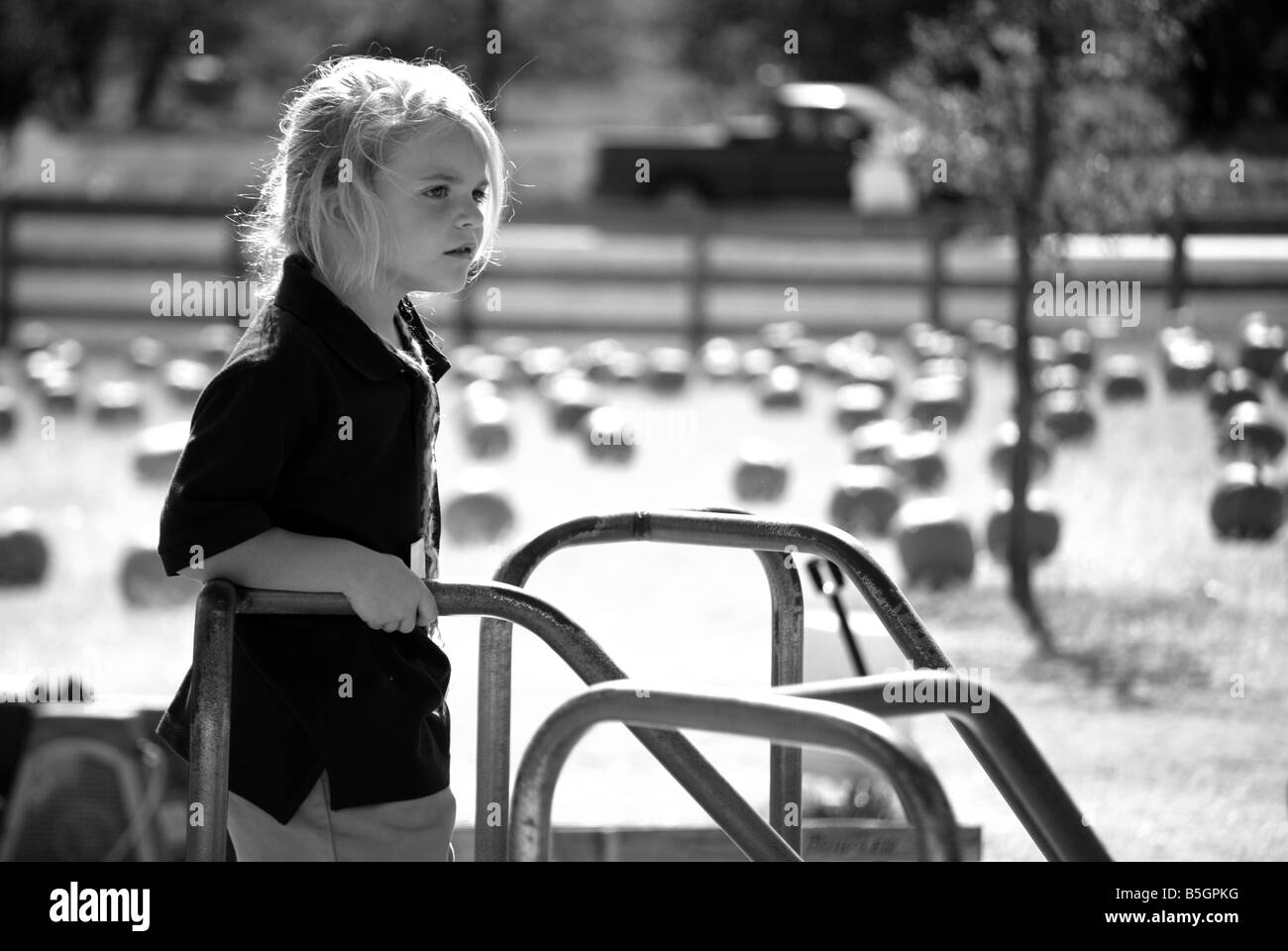 schwarz / weiß Bild eines Mädchens auf einem Karussell auf einem Spielplatz Stockfoto