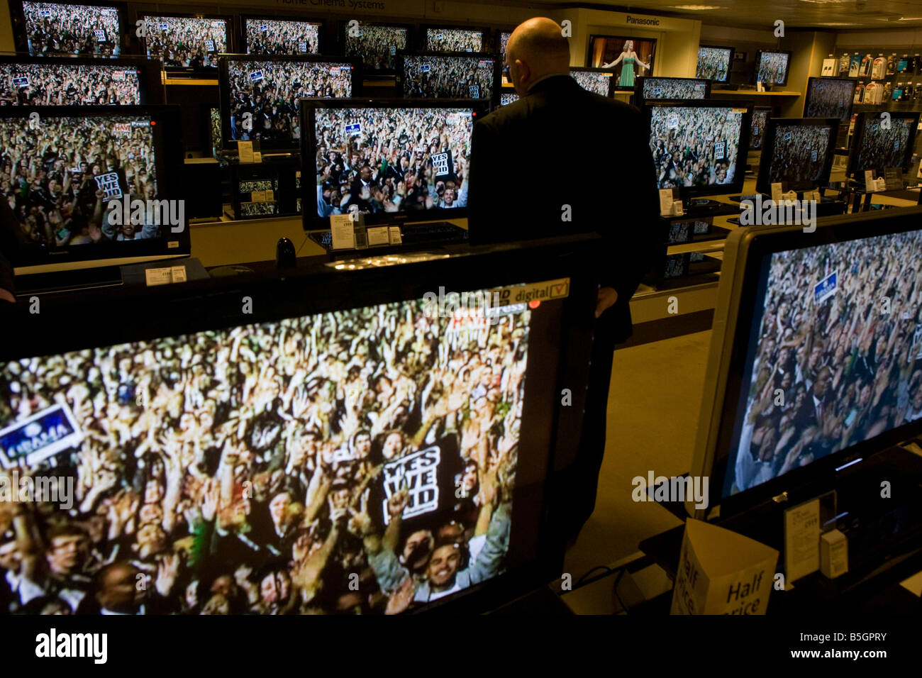 Shopper-Uhren Barack Obama Demokrat Anhänger Rallye gesehen auf BBC News TV-Bildschirmen im Kaufhaus John Lewis inszenieren Stockfoto